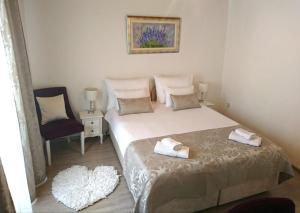 a small bedroom with a bed and a chair at Studio Sfinga in the heart of Diocletian's palace in Split