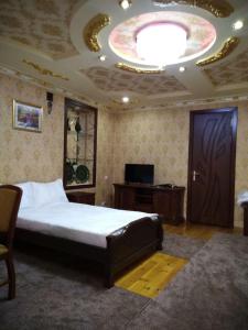 a bedroom with a large bed and a large ceiling at SHAHNOZA GRAND in Samarkand