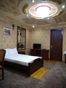 una camera con un grande letto e un grande soffitto di SHAHNOZA GRAND a Samarkand