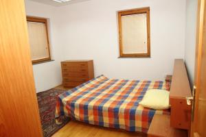 Apartman Goražde في Goražde: غرفة نوم صغيرة بها سرير ونوافذ