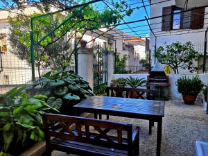 une terrasse avec une table, des bancs et des plantes dans l'établissement B&B Villa Passiaturo, à Peschici