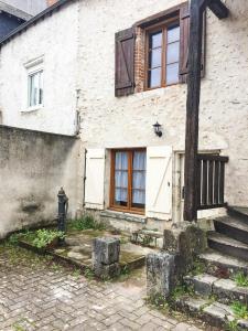 a white brick house with a door and a fire hydrant at L'hôte en pierre in Blois