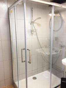 a shower with a glass door and a sink at L'hôte en pierre in Blois