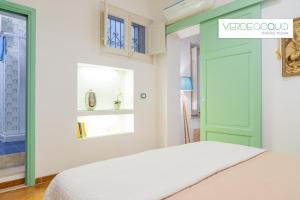 1 dormitorio con cama y puerta verde en Verdeacqua Holiday House, en Marinella di Selinunte