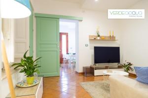 a living room with a couch and a tv at Verdeacqua Holiday House in Marinella di Selinunte