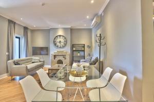 a living room with a glass table and white chairs at Warwick Mansions 7 in Cape Town