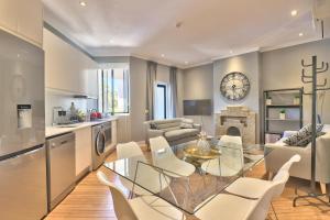 a kitchen and living room with a glass table and chairs at Warwick Mansions 7 in Cape Town