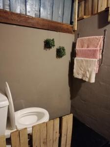 a bathroom with a toilet and towels on the wall at HostelBed @ Phitsanulok in Phitsanulok