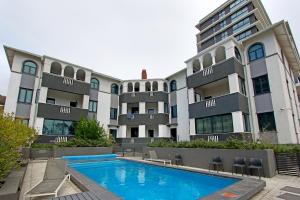 a building with a swimming pool in front of a building at Warwick Mansions 7 in Cape Town