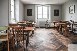 a restaurant with wooden tables and chairs and windows at Manoir de la Côte-Dieu in Porrentruy
