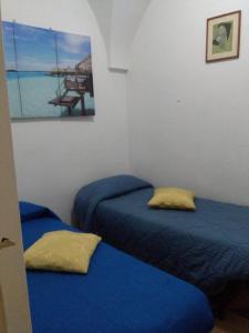 2 camas en una habitación con sábanas azules en House 1909, en Ostuni
