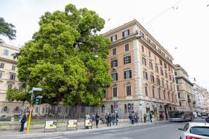 um grupo de pessoas andando em uma rua em frente a um edifício em AmoRoma Suite em Roma