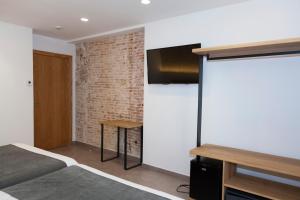 a bedroom with a bed and a brick wall at Hostal Paris in Barcelona