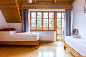a bedroom with two beds and a large window at udanypobyt Dom Z Ogrodem in Zakopane