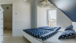 a bed with blue pillows in a white room at Hej na Mazury Apartamenty in Ruciane-Nida