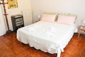 um quarto com uma grande cama branca com almofadas cor-de-rosa em Camera con Vista em Ancona
