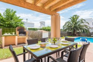 a patio with a table and chairs and a grill at Villa Laurax in Son Carrio