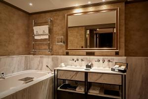 La salle de bains est pourvue d'une baignoire, d'un lavabo et d'un miroir. dans l'établissement Hotel TwentySeven - Small Luxury Hotels of the World, à Amsterdam