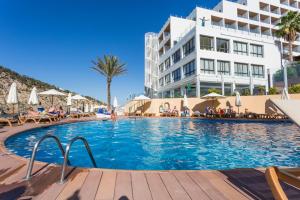 a swimming pool in front of a hotel at Palladium Hotel Cala Llonga - Adults Only in Cala Llonga