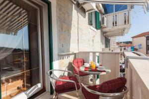 een balkon met een tafel, stoelen en een raam bij Apartments Kalalarga Deluxe- city centre&balcony in Makarska