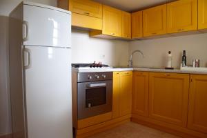 een keuken met gele kasten en een witte koelkast bij Fattoria Busa dell'Oro in Monte Ortone