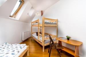 a room with a bed and a desk and bunk beds at Strych Kościuszki - duży in Szczecin