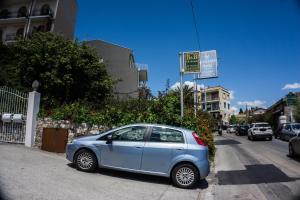 un pequeño coche azul estacionado al lado de una calle en Villa Moschella en Taormina