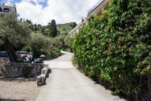 a sidewalk with a bench next to a bush at Villa Moschella in Taormina