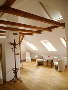 um quarto no sótão com clarabóias, cadeiras e uma mesa em Haus Vincent Stralsund em Stralsund