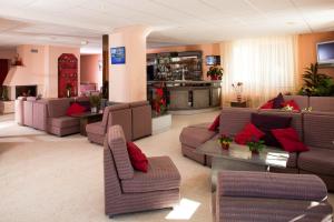 a living room with couches and red pillows at Hôtel Le Montaigu in Luz-Saint-Sauveur