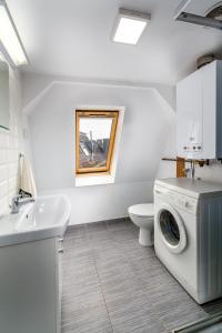 a bathroom with a washing machine and a sink at Strych Kościuszki - duży in Szczecin