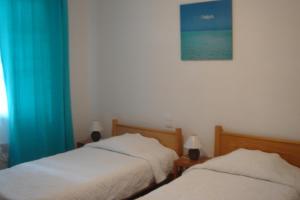 a bedroom with two beds and a blue curtain at Villa Etche Xuria in Biscarrosse-Plage