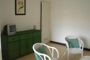 a room with two chairs and a tv on a dresser at Villa Etche Xuria in Biscarrosse-Plage
