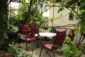 een tafel en stoelen in een tuin bij Görbe Vendégház magyar klasszika in Tarcal