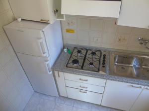 a small kitchen with a stove and a sink at Villa Valeria in Lignano Sabbiadoro