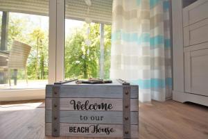 una caja de madera con las palabras bienvenida a nuestra casa de la playa en Ferienwohnung Küstenflair en Ostseebad Sellin
