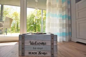 una caja de madera con las palabras bienvenida a nuestra casa de la playa en Ferienwohnung Küstenflair, en Ostseebad Sellin