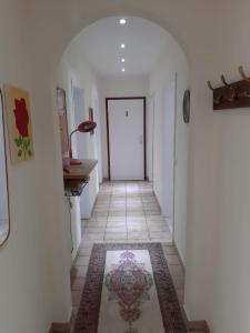 a hallway with a white door and a tile floor at Gästehaus Terrana in Wathlingen