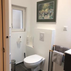 
a white toilet sitting next to a white sink at Bordeaux Village Blaye in Blaye
