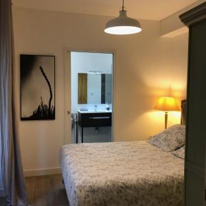 a bedroom with a bed and a bathroom with a sink at Bordeaux Village Blaye in Blaye