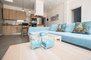 a living room with a blue couch and two fish tanks at Modern Spacious Apartment in Kissamos