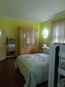 a bedroom with a bed and a mirror at Sua Casa na Serra in Itaipava