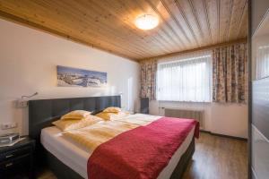 ein Schlafzimmer mit einem großen Bett mit einer roten Decke in der Unterkunft Appartementhaus Mühlberger in Ellmau