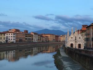 uitzicht op een rivier in een stad met gebouwen bij Podere Il Mulino in Pieve di Santa Luce