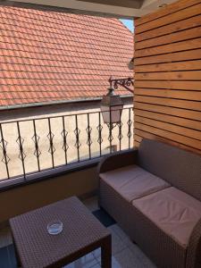 balcón con banco, mesa y techo en Appart LE COUCOU en Saint-Hippolyte