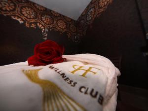 a red rose sitting on top of a white pillow at Hotel Porta Felice & Spa in Palermo