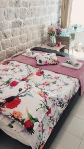 a bed with a floral comforter in a bedroom at Studio Apartment Legcevic in Kaštela