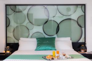 - un lit avec un oreiller vert et un plateau de nourriture dans l'établissement JC Hotel, à Rome