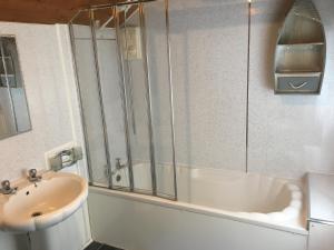 uma casa de banho com um chuveiro, um lavatório e uma banheira em Isambard Cottage em Weymouth