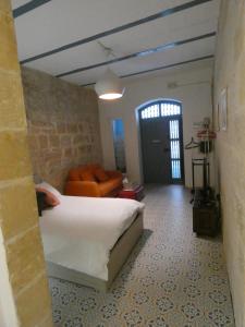een slaapkamer met een bed en een bank in een kamer bij Zekka Studio in Valletta
